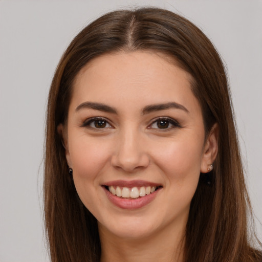 Joyful white young-adult female with long  brown hair and brown eyes