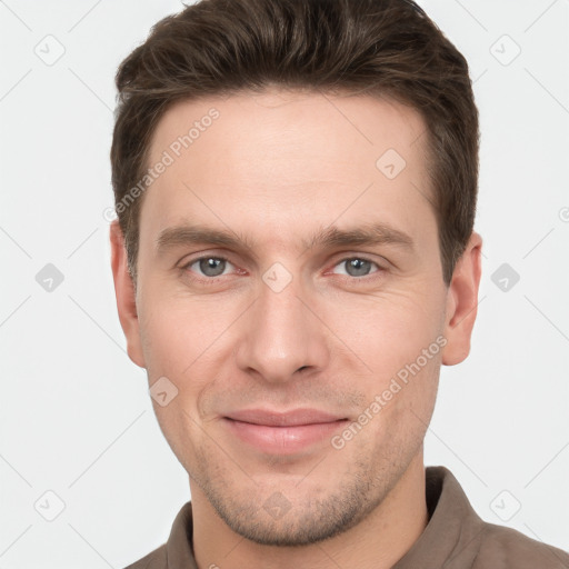 Joyful white young-adult male with short  brown hair and grey eyes