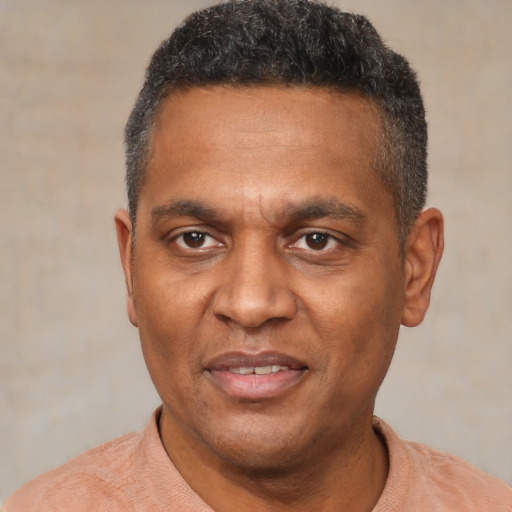 Joyful black adult male with short  brown hair and brown eyes