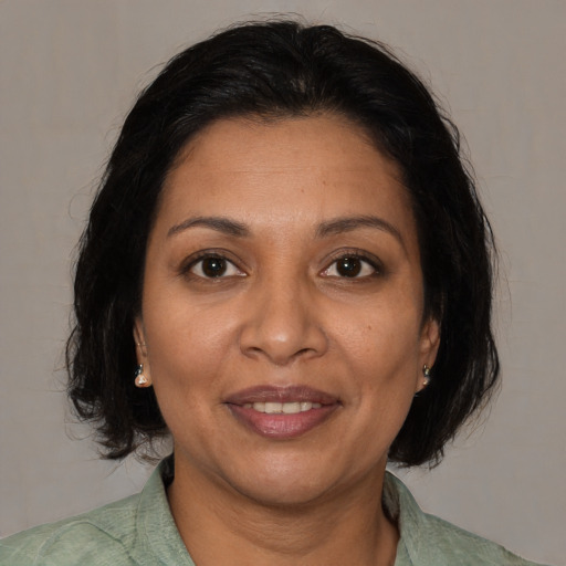 Joyful latino adult female with medium  brown hair and brown eyes
