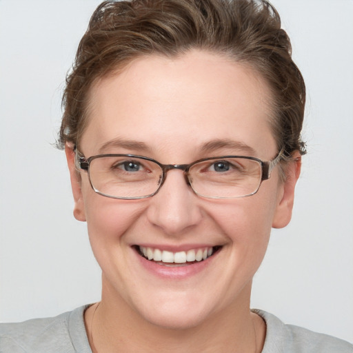 Joyful white adult female with short  brown hair and blue eyes