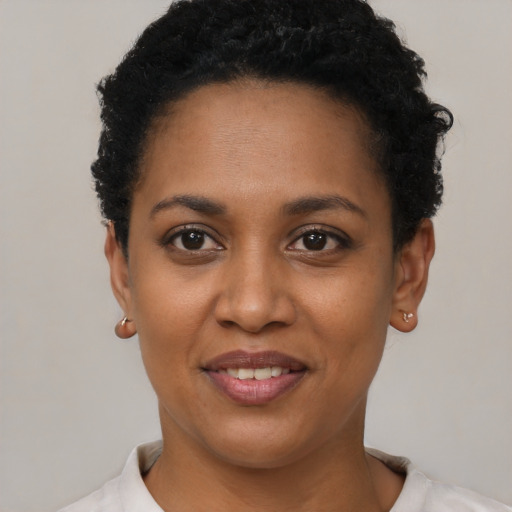 Joyful black young-adult female with short  black hair and brown eyes