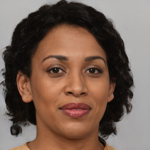 Joyful black adult female with medium  brown hair and brown eyes