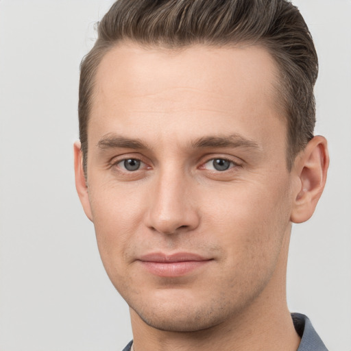 Joyful white young-adult male with short  brown hair and grey eyes