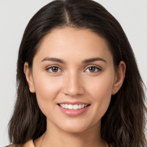 Joyful white young-adult female with long  brown hair and brown eyes