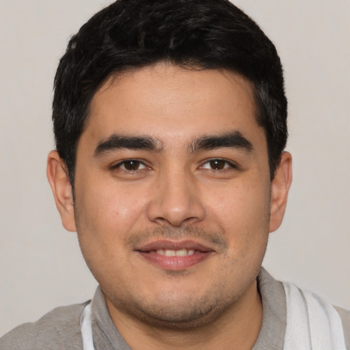 Joyful white young-adult male with short  black hair and brown eyes