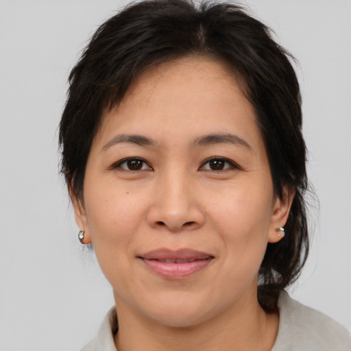 Joyful asian adult female with medium  brown hair and brown eyes