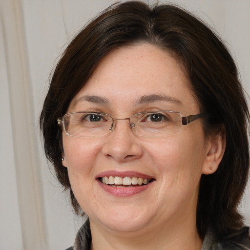 Joyful white adult female with medium  brown hair and brown eyes