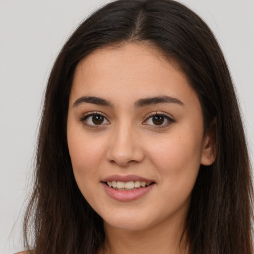 Joyful white young-adult female with long  brown hair and brown eyes