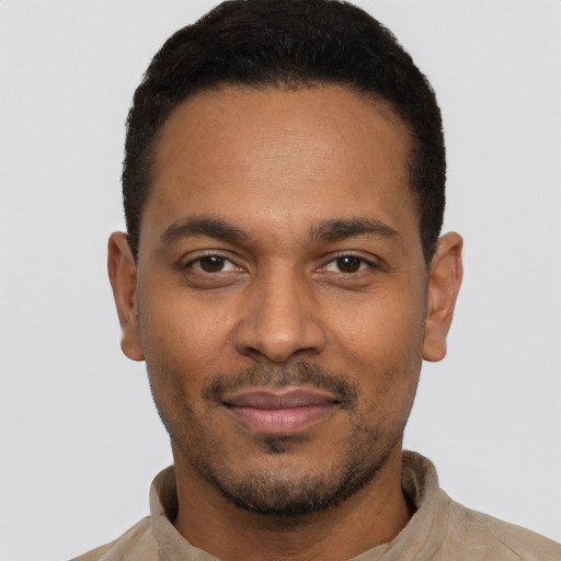 Joyful black young-adult male with short  black hair and brown eyes