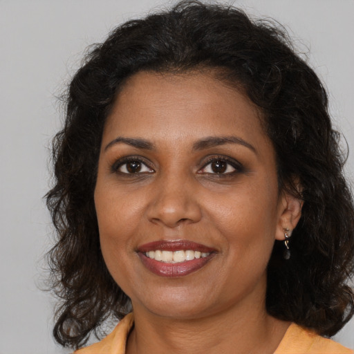 Joyful black adult female with medium  brown hair and brown eyes
