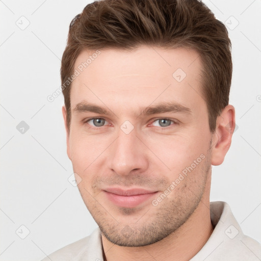 Joyful white young-adult male with short  brown hair and grey eyes