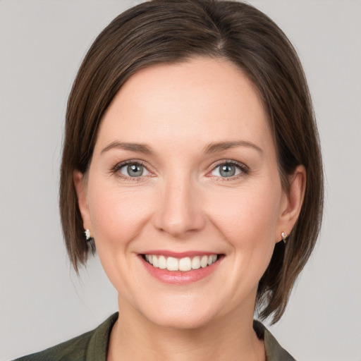 Joyful white young-adult female with medium  brown hair and grey eyes