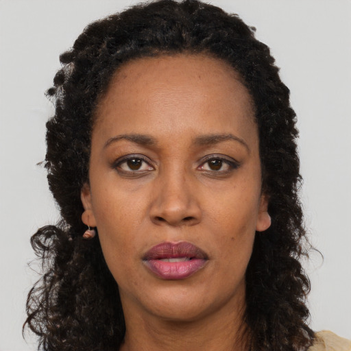 Joyful black adult female with long  brown hair and brown eyes