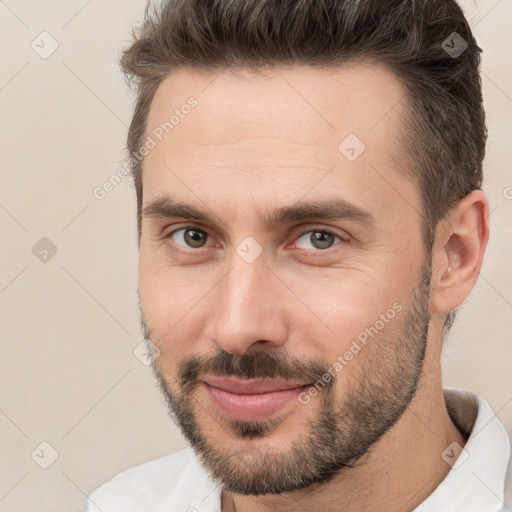 Joyful white adult male with short  brown hair and brown eyes