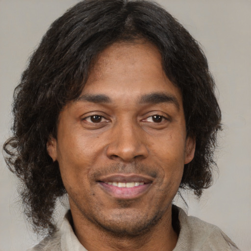 Joyful black adult male with medium  brown hair and brown eyes
