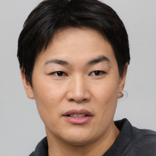 Joyful asian young-adult female with short  black hair and brown eyes
