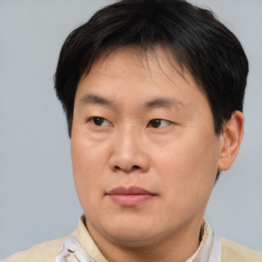 Joyful asian adult male with short  brown hair and brown eyes