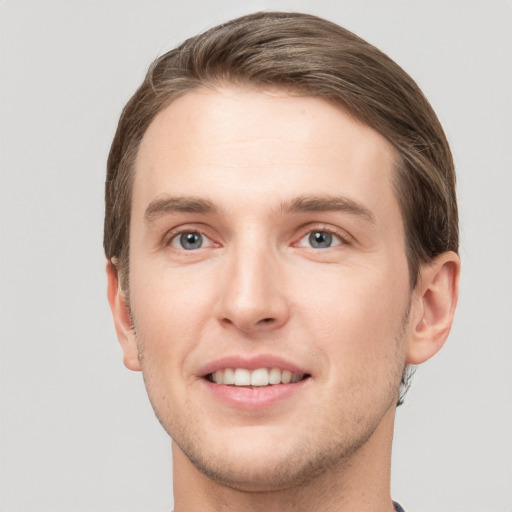 Joyful white young-adult male with short  brown hair and grey eyes