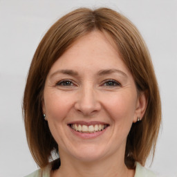 Joyful white adult female with medium  brown hair and grey eyes