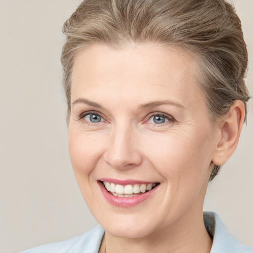 Joyful white adult female with medium  brown hair and grey eyes