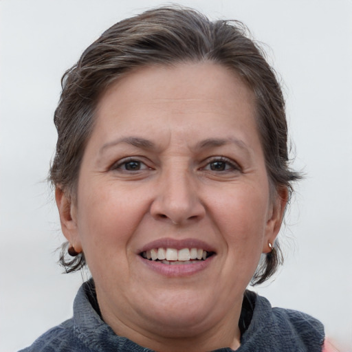 Joyful white adult female with medium  brown hair and blue eyes