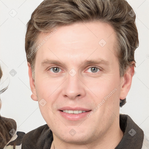 Joyful white adult male with short  brown hair and grey eyes