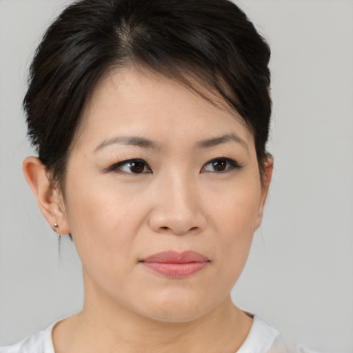 Joyful asian young-adult female with medium  brown hair and brown eyes