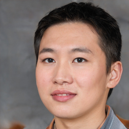 Joyful asian young-adult male with short  black hair and brown eyes