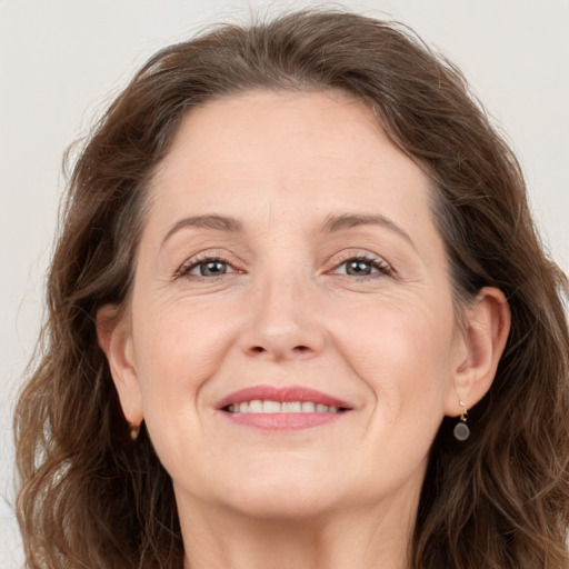 Joyful white adult female with long  brown hair and grey eyes