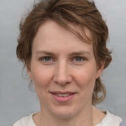 Joyful white adult female with medium  brown hair and blue eyes