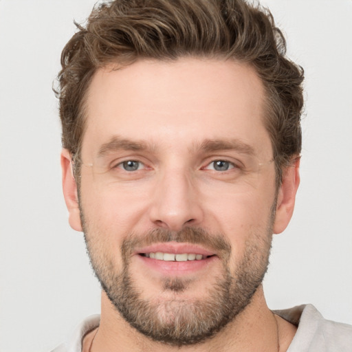 Joyful white young-adult male with short  brown hair and grey eyes