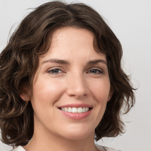 Joyful white young-adult female with medium  brown hair and green eyes