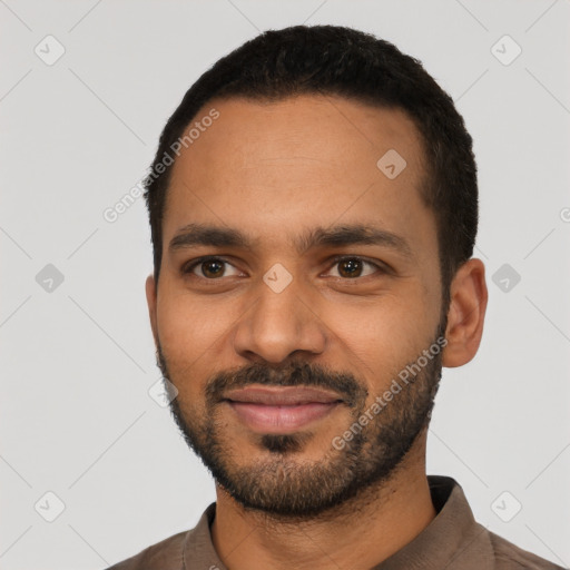 Joyful black young-adult male with short  black hair and brown eyes