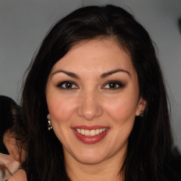 Joyful white adult female with long  brown hair and brown eyes