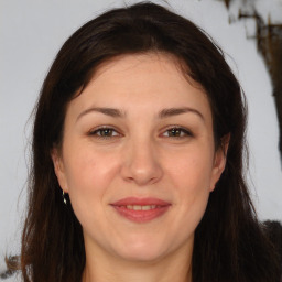 Joyful white adult female with long  brown hair and brown eyes