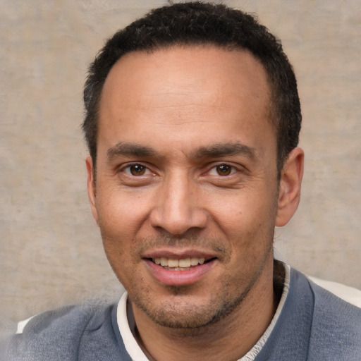 Joyful white adult male with short  black hair and brown eyes