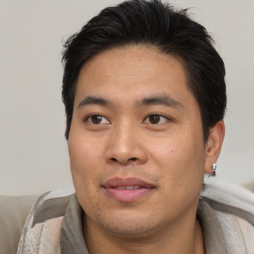 Joyful asian young-adult male with short  brown hair and brown eyes