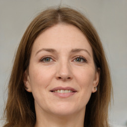 Joyful white adult female with long  brown hair and grey eyes