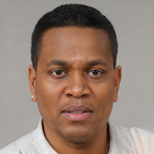 Joyful black adult male with short  black hair and brown eyes