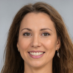 Joyful white adult female with long  brown hair and brown eyes