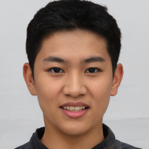 Joyful asian young-adult male with short  black hair and brown eyes