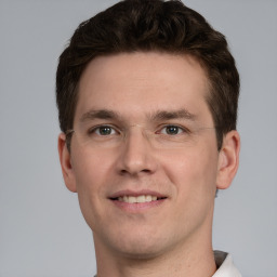 Joyful white young-adult male with short  brown hair and grey eyes