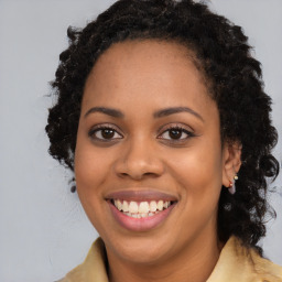 Joyful black young-adult female with long  brown hair and brown eyes