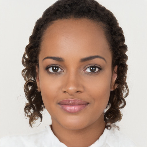 Joyful black young-adult female with long  brown hair and brown eyes