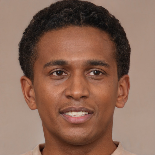 Joyful black young-adult male with short  brown hair and brown eyes