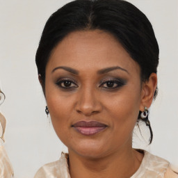 Joyful black adult female with medium  brown hair and brown eyes