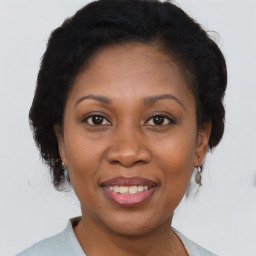 Joyful black adult female with medium  brown hair and brown eyes