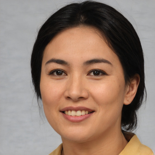 Joyful asian young-adult female with medium  brown hair and brown eyes