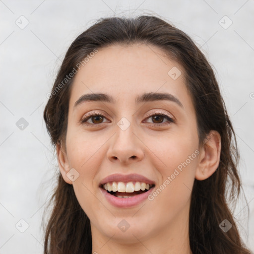 Joyful white young-adult female with long  brown hair and brown eyes